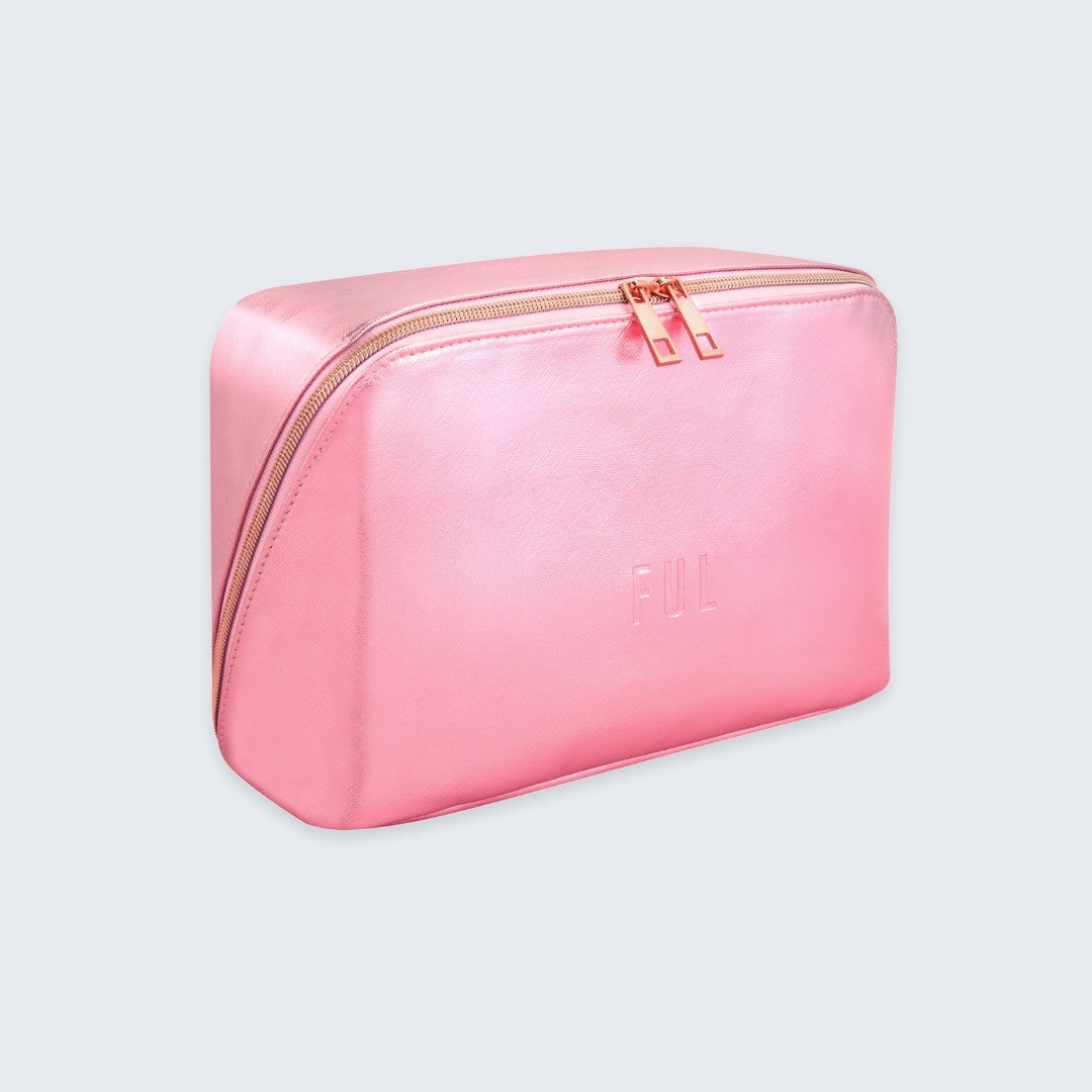 Pink toiletry bag with gold zipper on a light gray background