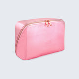 Pink toiletry bag with gold zipper on a light gray background