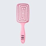 Pink paddle brush with textured handle on a light gray background