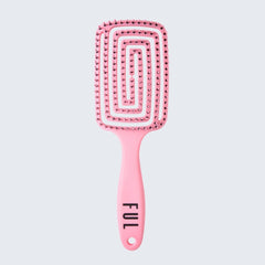 Pink paddle brush with textured handle on a light gray background