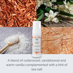 Product bottle with natural elements like wood chips, flowers, and sea salt on a wooden background.